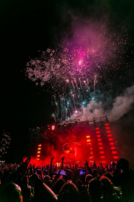 Energetic outdoor concert at night with a vibrant fireworks display and crowd enjoying live music.